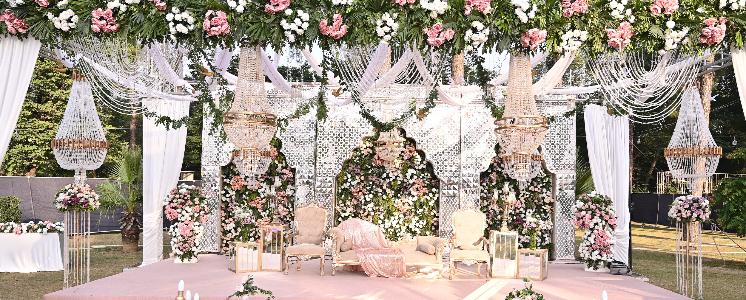 Vibrant mehendi decoration with a stunning white-themed backdrop and floral arrangements.