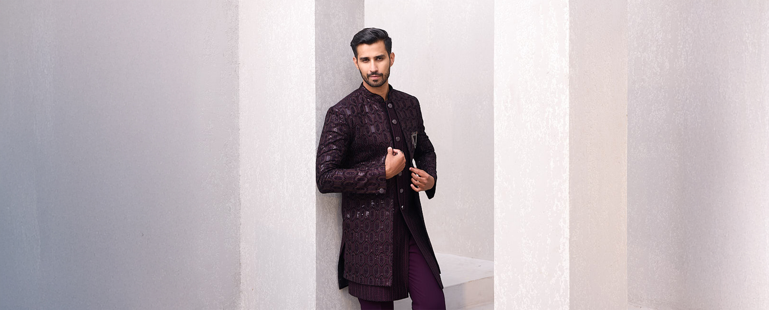 A groom wearing a sophisticated dark brown Indo-Western sherwani, exuding elegance and style.